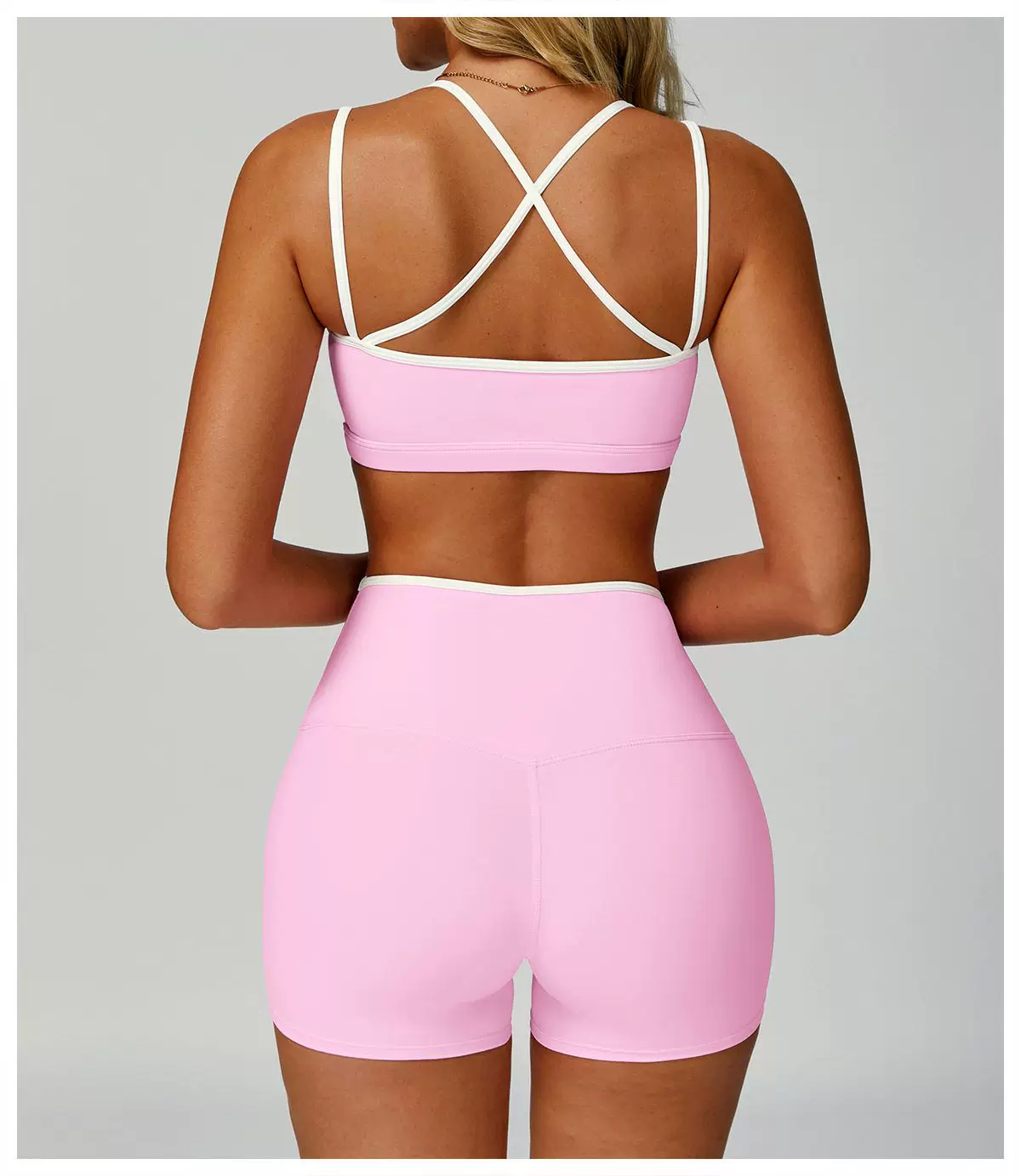 Pink cross-back sports bra and high-waist shorts set, back view