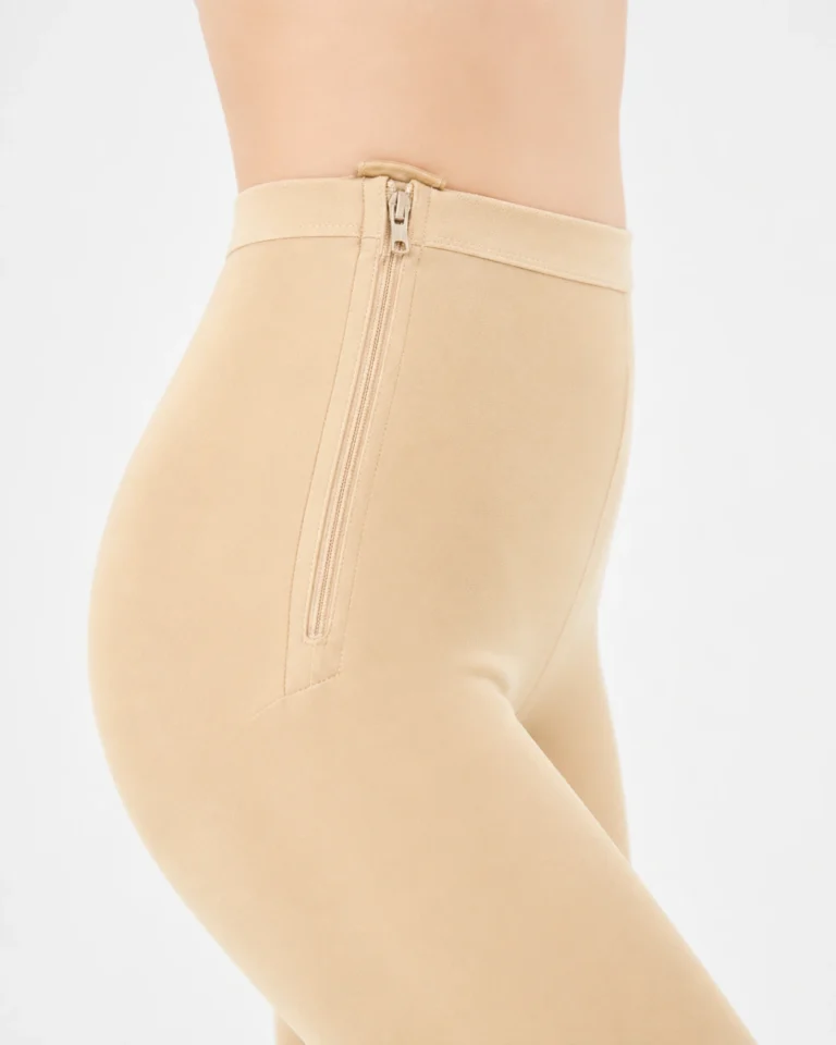 Skin Color compression leggings close-up showing the side zipper and waistband seams