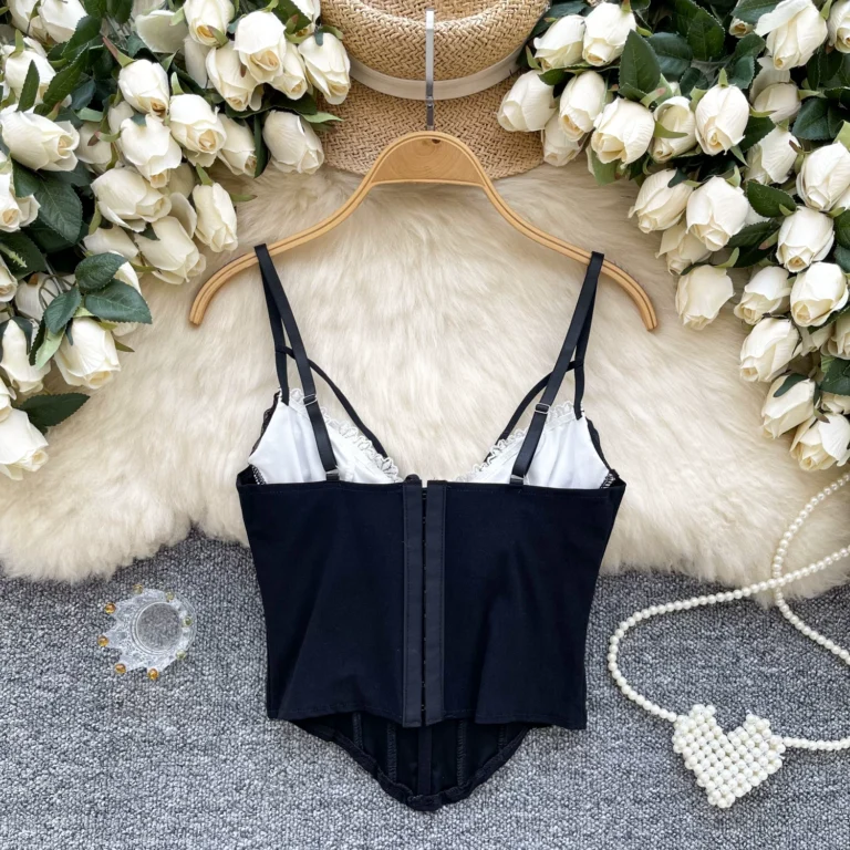 Black lace corset cami back view with adjustable straps, white cup lining and hook-and-eye closure