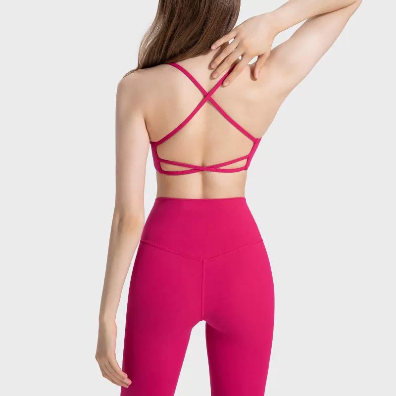Pink sports bra with thin crisscross straps and lower double-strap back