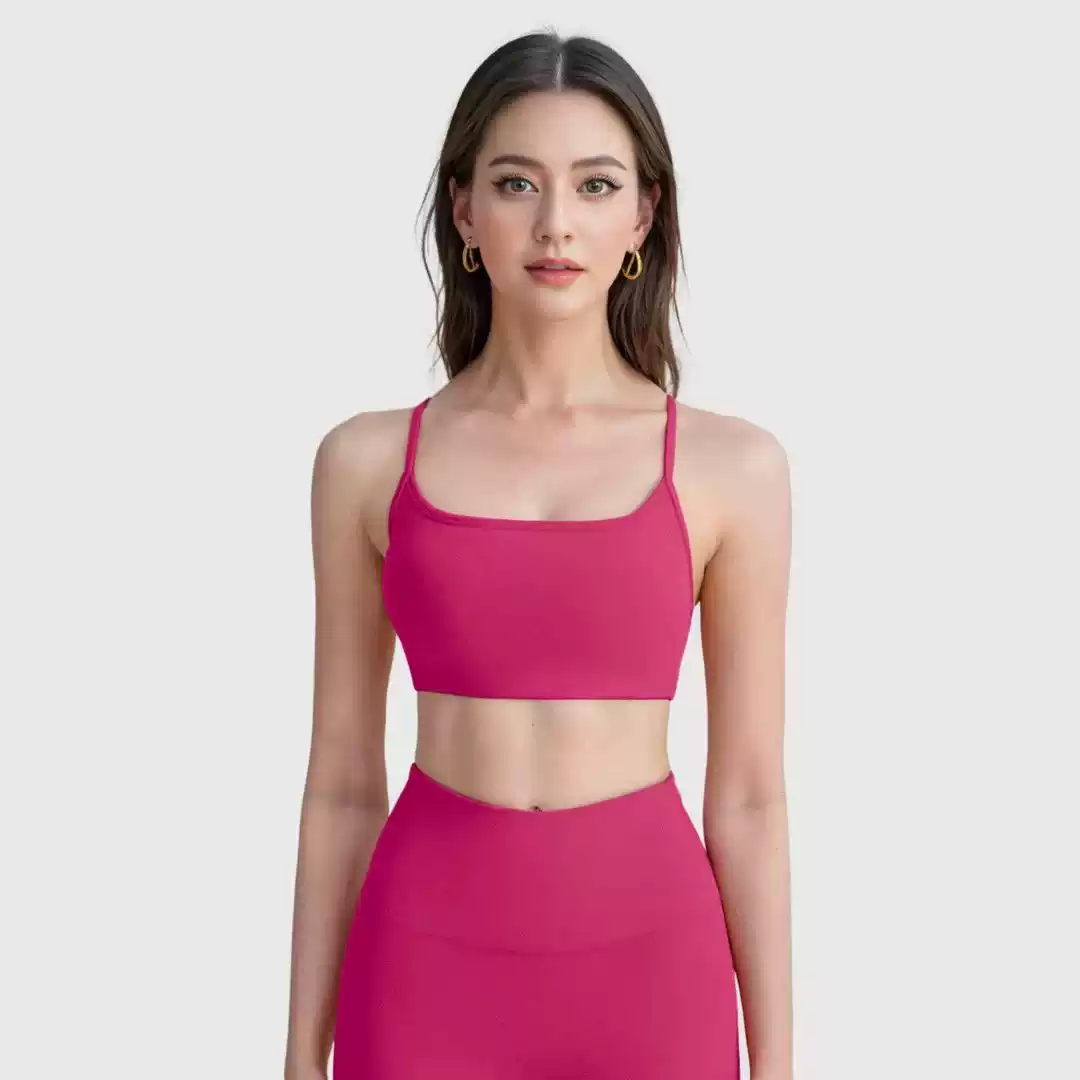 Pink scoop-front crisscross sports bra crop top, studio front view