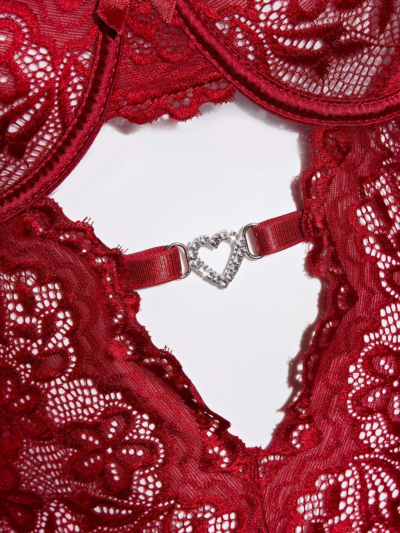 Decorative heart-shaped center-front hardware and open lace panel detail