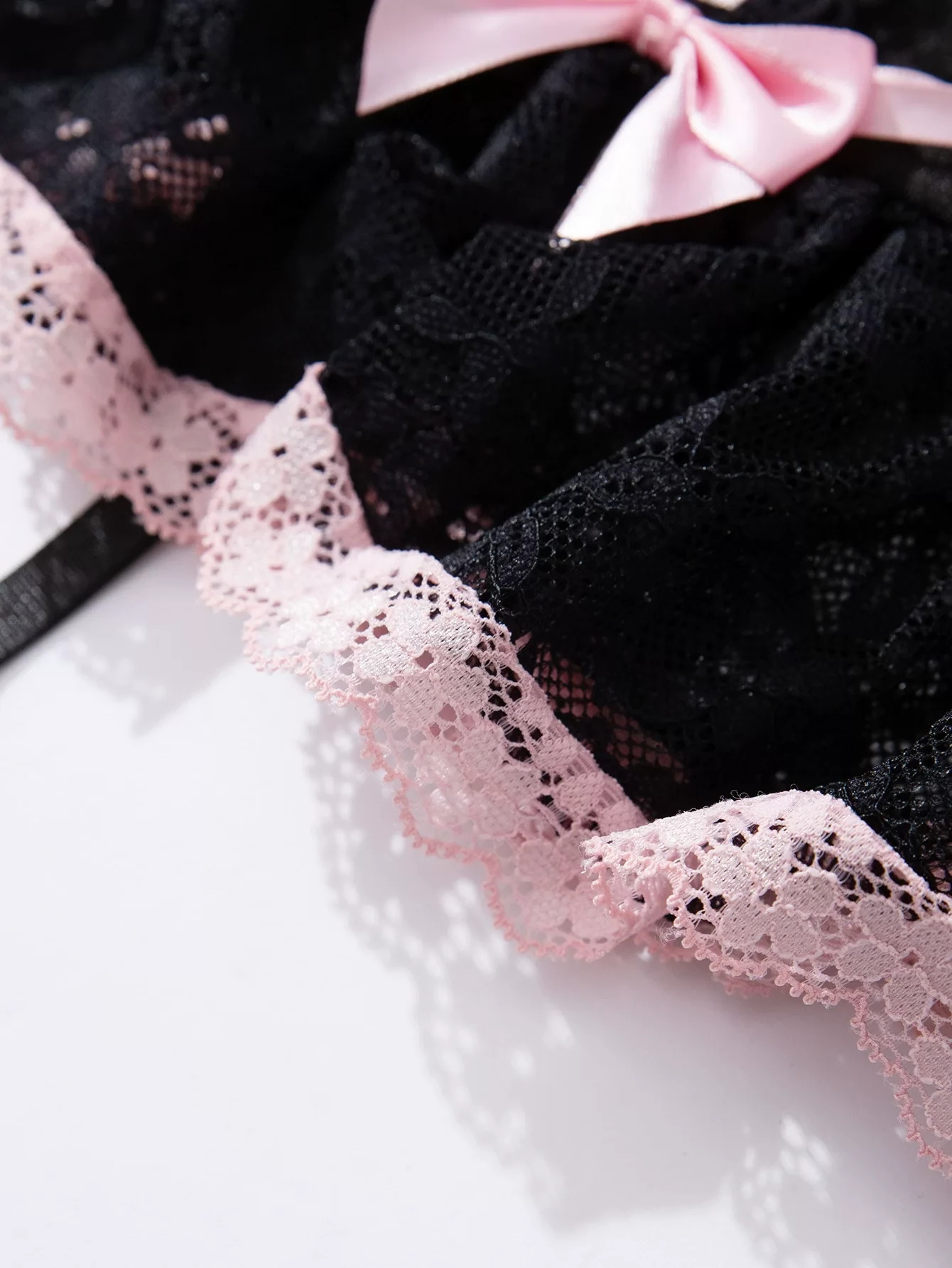 Qinelle black lace hem with pink trim close-up detail