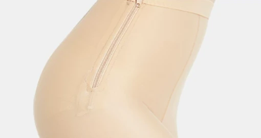 Nude compression leggings side zipper close-up