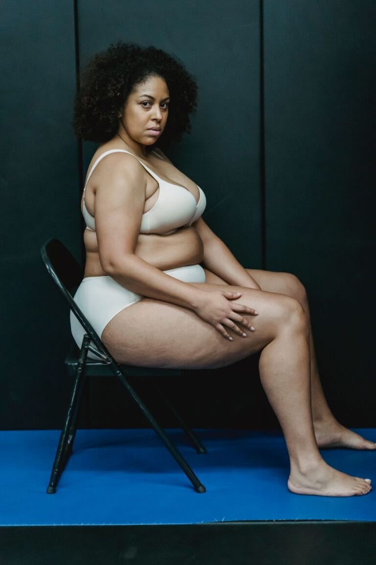 Plus-size woman sitting on a chair for a seated shapewear stability check